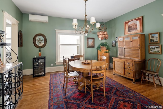 dining space featuring wine cooler, a wall mounted air conditioner, wood finished floors, and baseboards