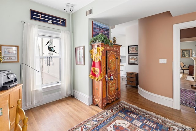 interior space with visible vents, light wood-style flooring, and baseboards