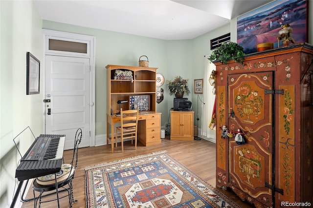 office space with light wood-style floors and baseboards