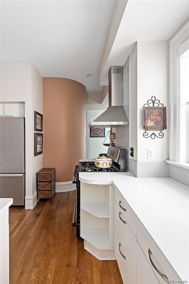 kitchen with stainless steel appliances, white cabinetry, wall chimney range hood, open shelves, and dark wood finished floors