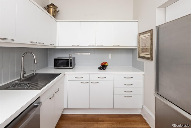 kitchen featuring appliances with stainless steel finishes, light countertops, and a sink