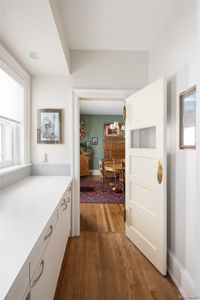 hall featuring dark wood-style floors and baseboards