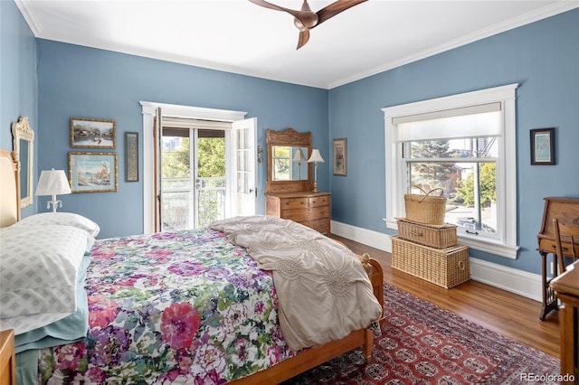 bedroom with access to outside, multiple windows, crown molding, and wood finished floors