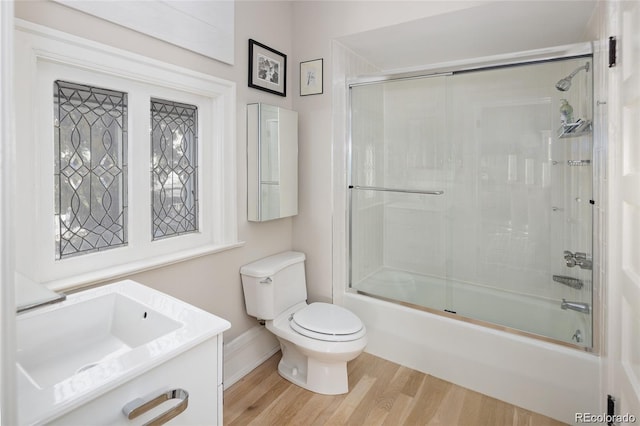 full bathroom featuring enclosed tub / shower combo, vanity, wood finished floors, and toilet