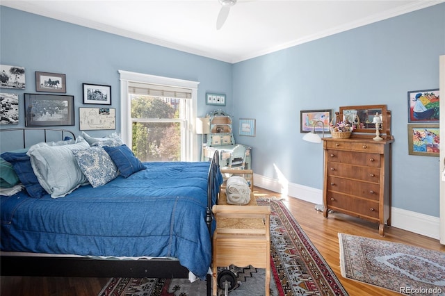 bedroom with crown molding, baseboards, ceiling fan, and wood finished floors