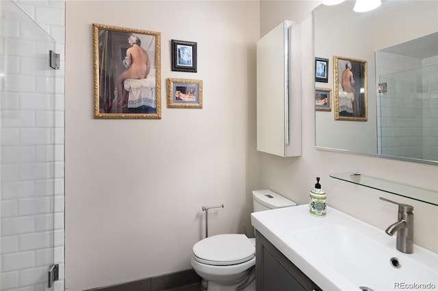 full bathroom with a tile shower, vanity, and toilet