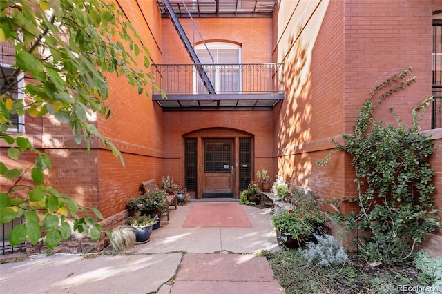 property entrance featuring a balcony and brick siding