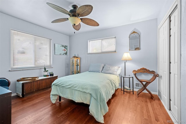 bedroom featuring ceiling fan, a closet, baseboards, and wood finished floors