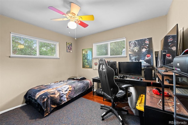 bedroom with ceiling fan, baseboards, and wood finished floors