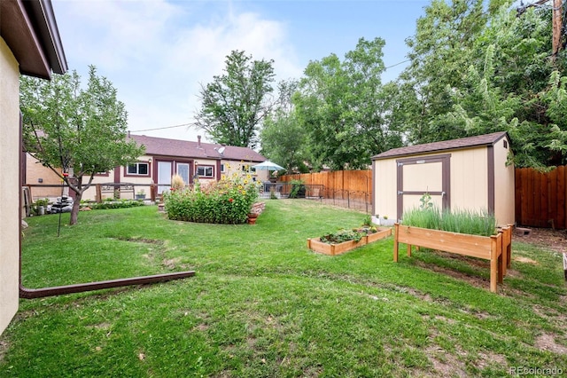 view of yard with an outbuilding, a garden, a fenced backyard, and a storage unit