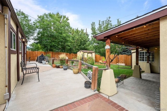 view of patio / terrace with an outbuilding, a fenced backyard, and a shed