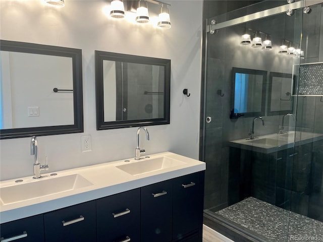 bathroom with a shower with shower door and vanity