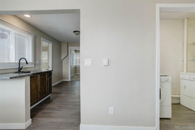 kitchen with hardwood / wood-style floors, sink, dark stone counters, and plenty of natural light