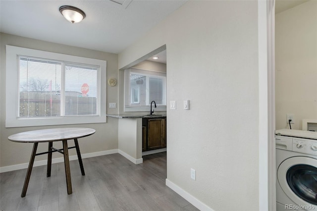 laundry area featuring sink, light hardwood / wood-style floors, and washer / clothes dryer