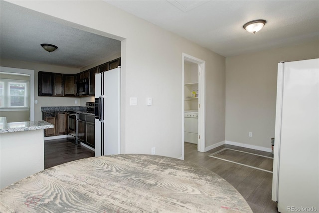 kitchen featuring light stone counters, dark wood-type flooring, appliances with stainless steel finishes, and dark brown cabinetry