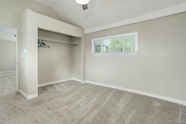 unfurnished bedroom with carpet flooring, a closet, ceiling fan, and vaulted ceiling