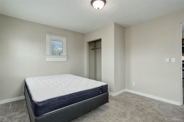 carpeted bedroom with a closet and a textured ceiling