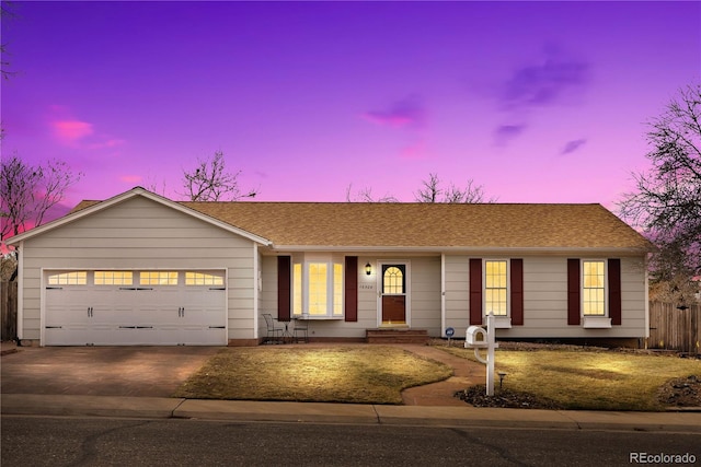 ranch-style home with a garage, concrete driveway, roof with shingles, and fence