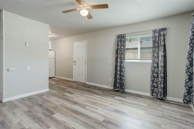 empty room featuring ceiling fan and light hardwood / wood-style flooring