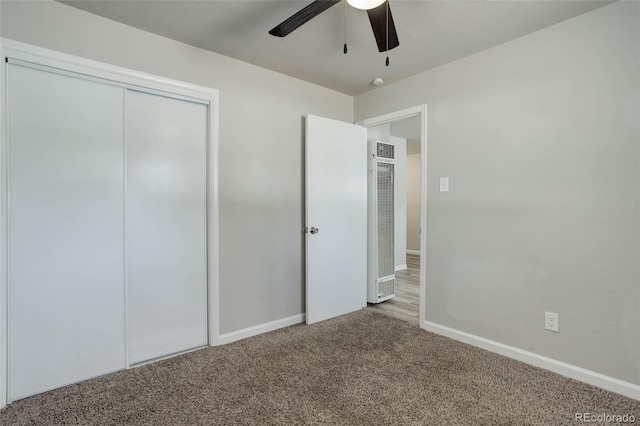 unfurnished bedroom with ceiling fan, light colored carpet, and a closet