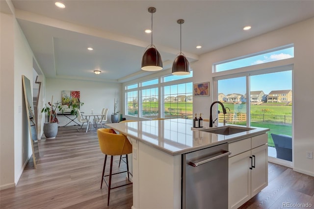 kitchen with white cabinets, dishwasher, a center island with sink, and sink