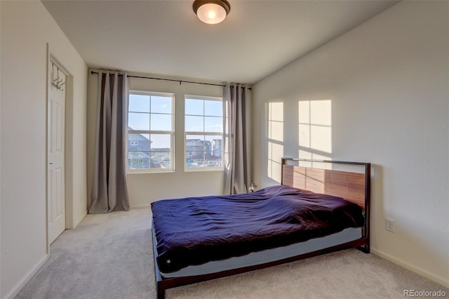 carpeted bedroom with lofted ceiling