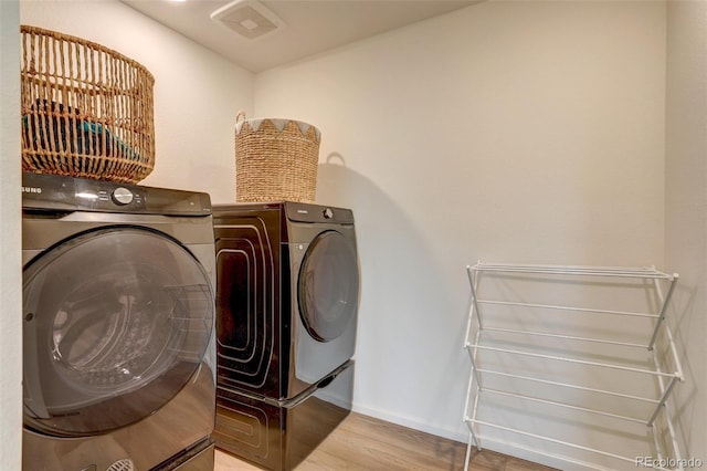 washroom featuring washer and clothes dryer and hardwood / wood-style flooring