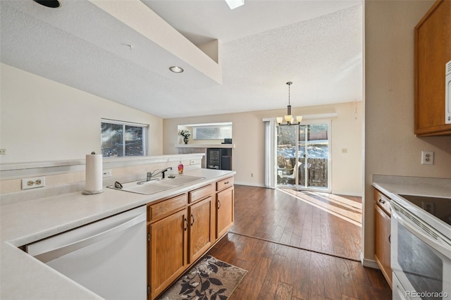 kitchen with dark wood-type flooring, sink, hanging light fixtures, a textured ceiling, and white appliances