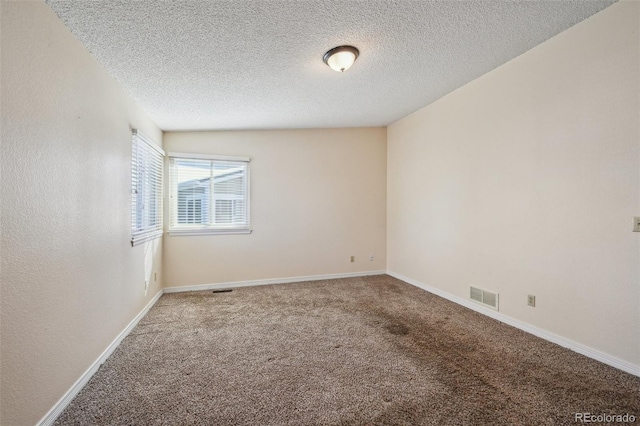 carpeted empty room with a textured ceiling