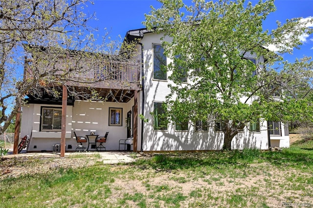 1673 Woodmoor Dr, Monument, CO 80132 - rear view of property featuring stucco siding, a balcony, and a patio