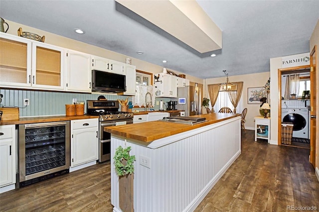 1673 Woodmoor Dr, Monument, CO 80132 - kitchen with beverage cooler, appliances with stainless steel finishes, wood counters, washer / clothes dryer, and dark wood-type flooring