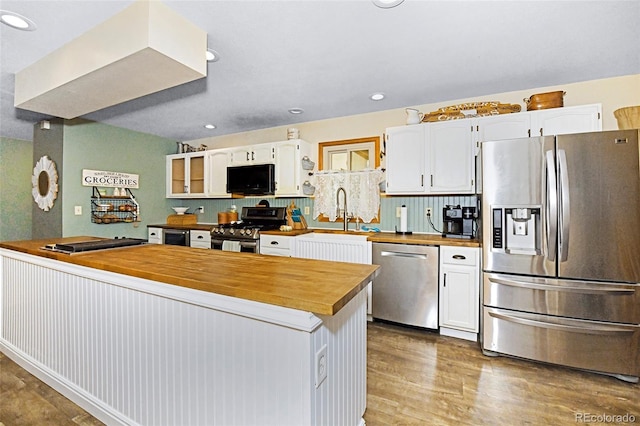 1673 Woodmoor Dr, Monument, CO 80132 - kitchen with stainless steel appliances, wooden counters, wood finished floors, white cabinets, and recessed lighting