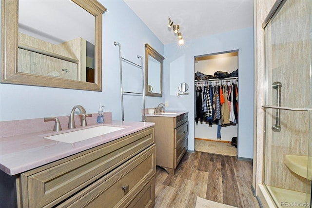 1673 Woodmoor Dr, Monument, CO 80132 - full bath with wood finished floors, a stall shower, two vanities, and a walk in closet