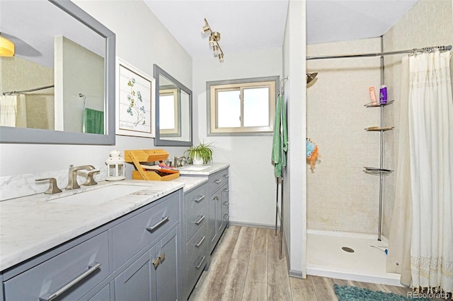 1673 Woodmoor Dr, Monument, CO 80132 - full bathroom featuring wood finished floors, a tile shower, and vanity