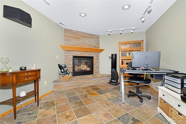 1673 Woodmoor Dr, Monument, CO 80132 - home office with a stone fireplace, stone finish flooring, rail lighting, and baseboards