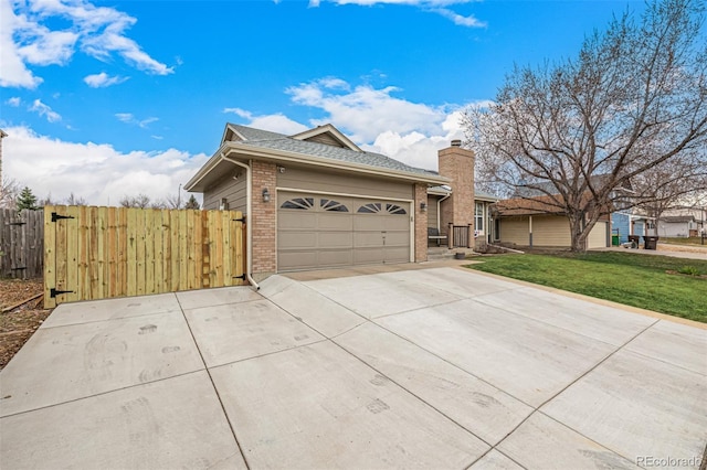 ranch-style house with a gate, concrete driveway, a front yard, an attached garage, and brick siding