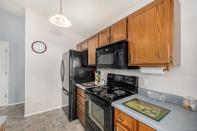 kitchen featuring brown cabinets, black appliances, a textured ceiling, light countertops, and baseboards