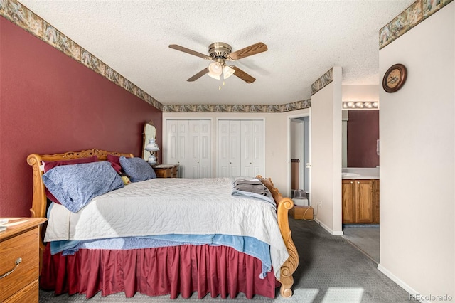 bedroom with baseboards, carpet, multiple closets, ensuite bathroom, and a textured ceiling