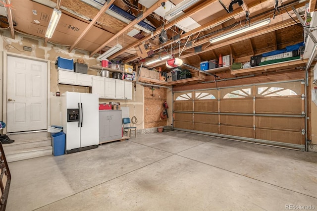 garage featuring white refrigerator with ice dispenser