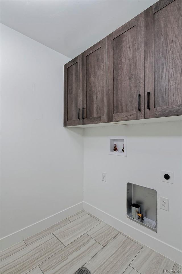 laundry room with electric dryer hookup, hookup for a washing machine, and cabinets