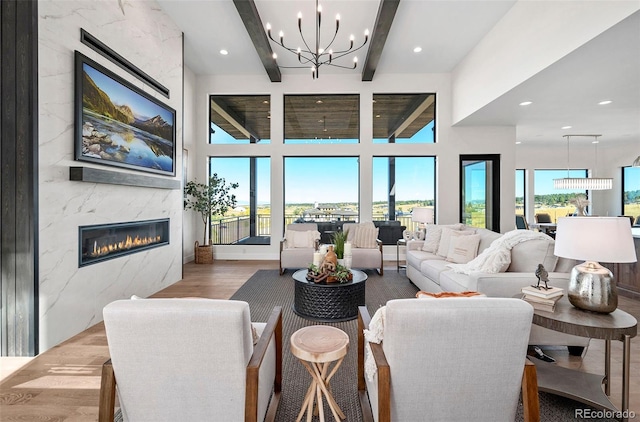 living room with beam ceiling, a fireplace, a wealth of natural light, and hardwood / wood-style flooring