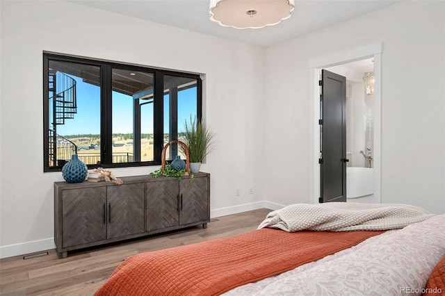 bedroom with wood-type flooring and ensuite bath