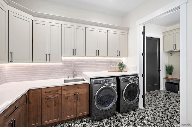 laundry area featuring sink, washer and dryer, and cabinets