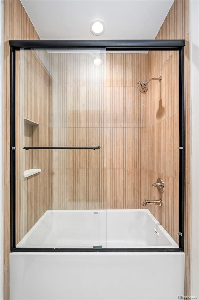 bathroom with combined bath / shower with glass door