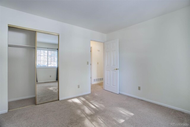 unfurnished bedroom with a closet and carpet flooring