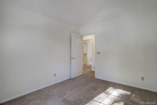 empty room with high vaulted ceiling and light carpet