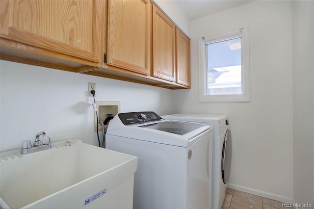 laundry area with sink, light tile patterned floors, cabinets, and independent washer and dryer