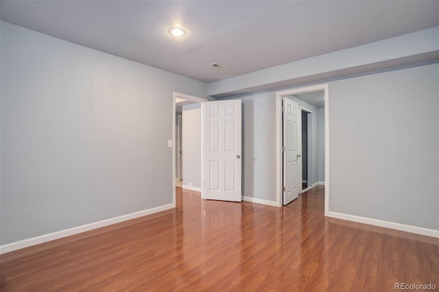 empty room with hardwood / wood-style floors and a textured ceiling