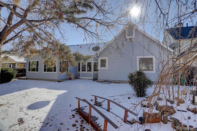 view of snow covered rear of property