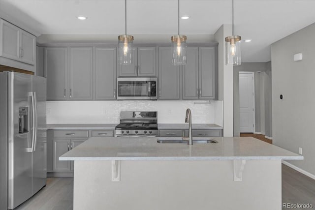 12862 Crane River Dr, Longmont, CO 80504 - kitchen with appliances with stainless steel finishes, gray cabinets, light wood finished floors, and recessed lighting